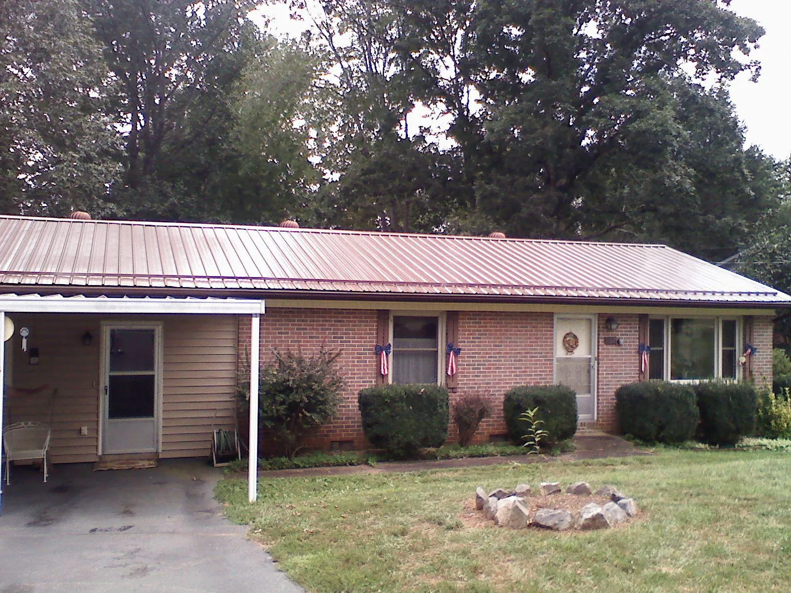 Bronze metal roof and carport on a brick ranch home — Roof Repair work by our crew in Sycamore